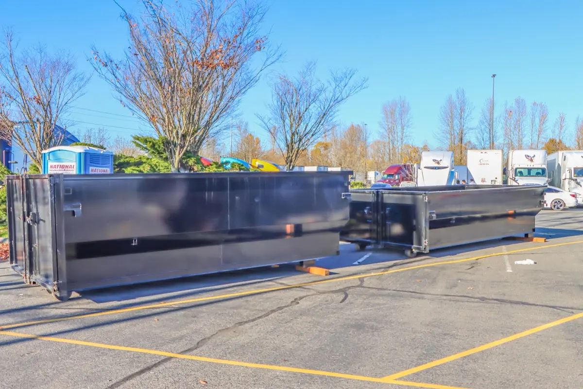Professional dumpster rental service with roll-off container on residential driveway in Demarest